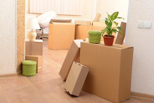 Movers carrying packed boxes from a flat